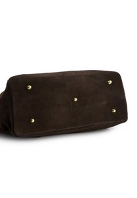Brown suede bag with a rectangular shape, featuring gold metal studs on the bottom for stability and accents. Soft texture, minimal detailing.
