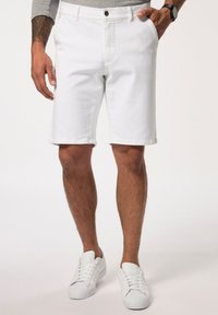 Vita denimshorts med rak skärning, med en framdragkedja och knappstängning, sidofickor och sydd fåll. Bärs med vita sneakers.