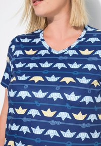 Námořnické tričko s potiskem origami lodí ve světle modré a žluté barvě, s designem v-výstřihu a měkkou texturou látky.