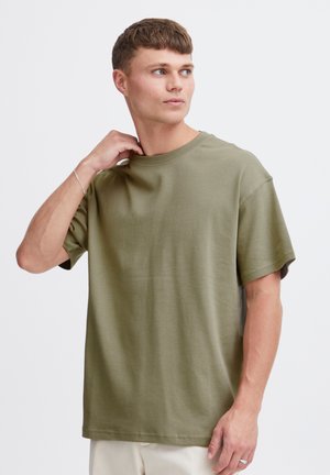 T-shirt vert olive à manches courtes en coton doux, offrant une coupe décontractée et un col rond, avec une texture lisse et sans ornements.