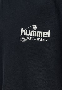 Tissu de sport noir avec une texture lisse arborant le logo "hummel" en blanc et un graphique lié au sport. Design simple et minimaliste.