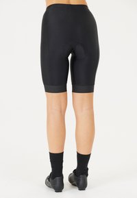 Svarta cykelshorts med en tajt design, utrustad med en vadderad sits och en slät yta. Shortsen har en längd som når mitt på låret och kontrasterande benband.
