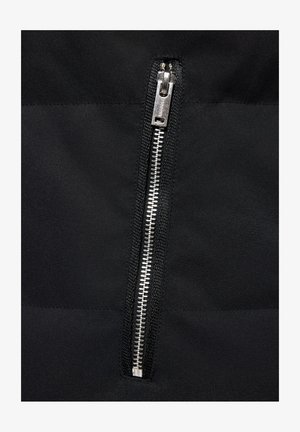 Czarny zamek błyskawiczny z metalowymi zębami i suwakiem na teksturowanej tkaninie, z matowym wykończeniem i eleganckim, minimalistycznym designem.