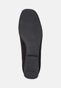 Svart sko sula med texturerad gummi och en slät del vid hälen. Designen är minimalistisk utan synliga mönster eller detaljer.