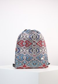 Reppumochi, joka on varustettu monivärisellä geometrisellä kuviolla punaisessa, sinisessä ja mustassa, valmistettu kestävästä kankaasta ja säädettävästä hihnasta.