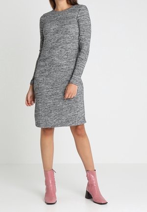 Robe cintrée à manches longues gris clair, texture douce et longueur mi-genou. Associée à des bottines roses jusqu'à la cheville avec un bout pointu.