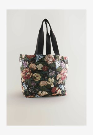 Torba tote w kwiaty na czarnym tle z czerwonymi, różowymi i niebieskimi kwiatami, z solidnymi czarnymi uchwytami, wyeksponowana na jasnym tle.