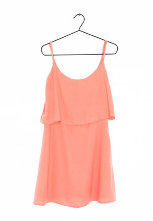 Korallowa sukienka bez rękawów wisząca na wieszaku, wyróżniająca się warstwowym fasonem i luźnym krojem, wykonana z lekkiego materiału o gładkiej fakturze.