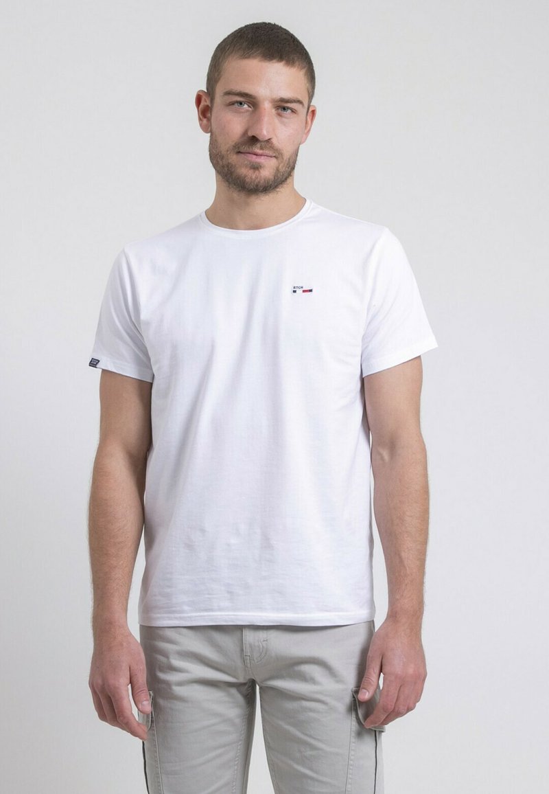 T-shirt en coton blanc avec col rond, manches courtes, présentant un petit logo multicolore sur la poitrine gauche et un design décontracté.
