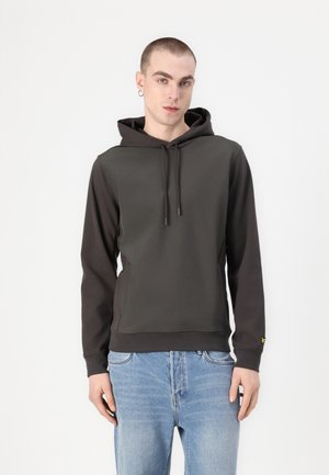 Sweat à capuche gris foncé avec cordon de serrage, poches avant et accents gris clair contrastants. Porté avec un jean en denim bleu clair.