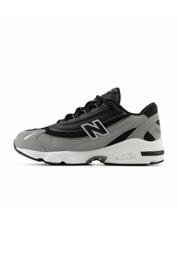 Sneaker New Balance nero e grigio con suola bianca, tomaia in mesh e materiale sintetico, e logo "N" sul lato, mostrato in vista laterale.