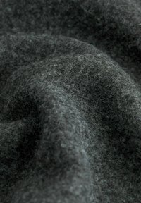 Sötét szürke gyapjúanyag, amelynek puha, texturált felülete van, finom szálakkal és enyhén bolyhos megjelenéssel.