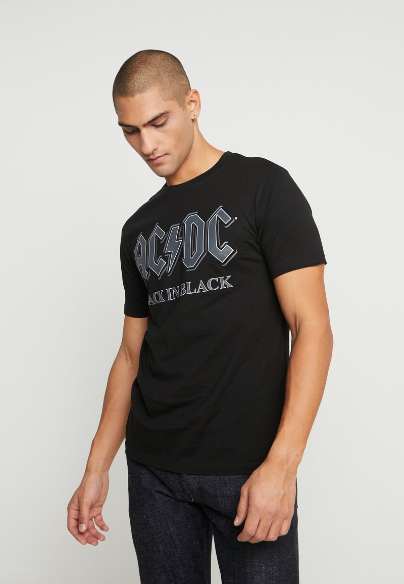 Black cotton t-shirt featuring gray graphic text "AC/DC BACK IN BLACK" with lightning bolt accent. Short sleeves and crew neck design.
