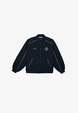 Marineblå bomberjakke med knaplukning, hvid piping langs sømmene, broderet logo på brystet og sidelommer.