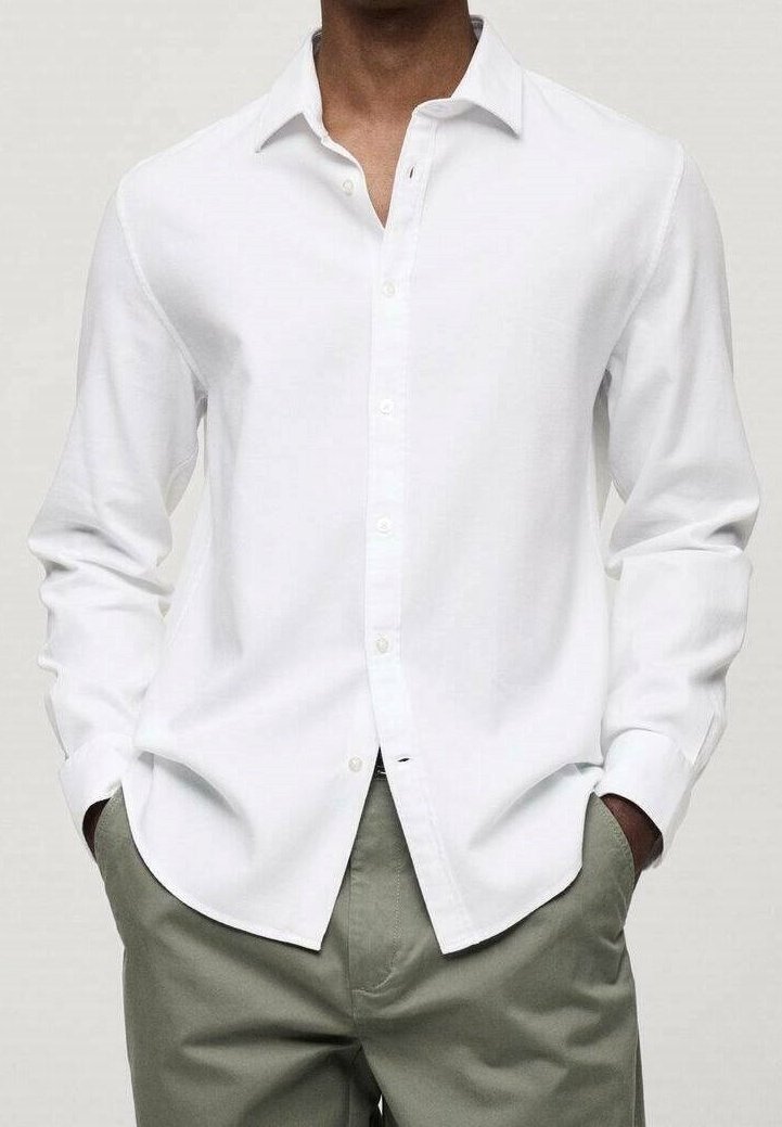 Camisa blanca de manga larga con botones y cuello clásico, hecha de una tela suave, combinada con pantalones de color verde claro, que presentan un ajuste relajado.