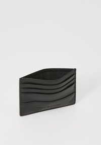 Svart lær kortholder med bølget mønstertekstur, som har flere spor og preget merkevare på siden. Kompakt og funksjonell design.