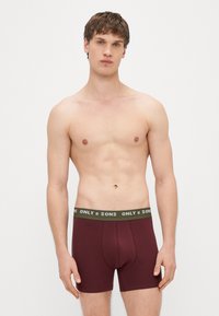 Bordowe bokserki o dopasowanym kroju z zielonym elastycznym pasem w talii, na którym znajduje się biały napis "ONLY & SONS".