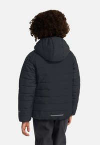 Chaqueta acolchada negra con capucha, con costuras horizontales, un acento reflectante en la parte trasera y una textura suave.