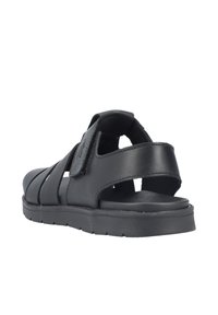 Sandales en cuir noir avec plusieurs sangles, une fermeture velcro et une semelle en caoutchouc, présentant un dos ouvert et une texture lisse.