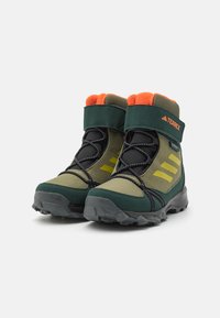 Zielone i szare buty trekkingowe z pomarańczowym polarem w środku, gumową podeszwą i czarnymi sznurówkami, z trzema żółtymi paskami po boku.