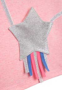 Rosa Hemd mit einem großen silbernen Glitzerstern und blauen, rosafarbenen sowie silbernen Bändern, die am unteren Rand hängen. Weiche Stofftextur.