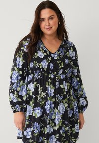 Floral dress in zwart materiaal met blauwe en groene bloemen, V-halslijn, geplooide lijfje en lange pofmouwen met elastische manchetten.