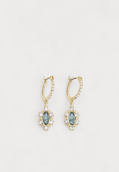 Orecchini a cerchio in oro con una pietra blu a taglio marquise circondata da piccole pietre di strass trasparenti e con una finitura lucida.