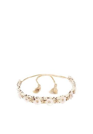 Diadema de cuentas con una base de tela de color beige claro, adornada con acentos perlados, embellishments florales y ataduras de borlas.