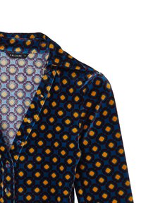 Camicia di velluto caratterizzata da un vivace motivo geometrico di cerchi nei colori giallo, arancione e blu scuro, con colletto a scollatura e bottoni.