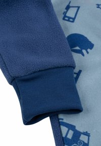 Tessuto in pile blu con finitura testurizzata. Polsino a costine con interno liscio. Sfondo azzurro chiaro con motivi di animali e oggetti blu scuro.