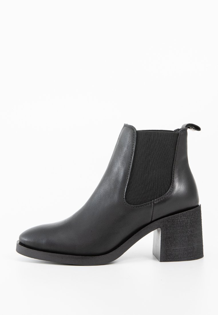 Stivale alla caviglia in pelle nera con pannello elastico laterale e tacco spesso, progettato per una vestibilità aderente e uno stile moderno.