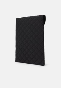Mască de tabletă neagră, cu un model de diamant, cu o textură de țesătură moale și o margine superioară rotunjită pentru un acces ușor.