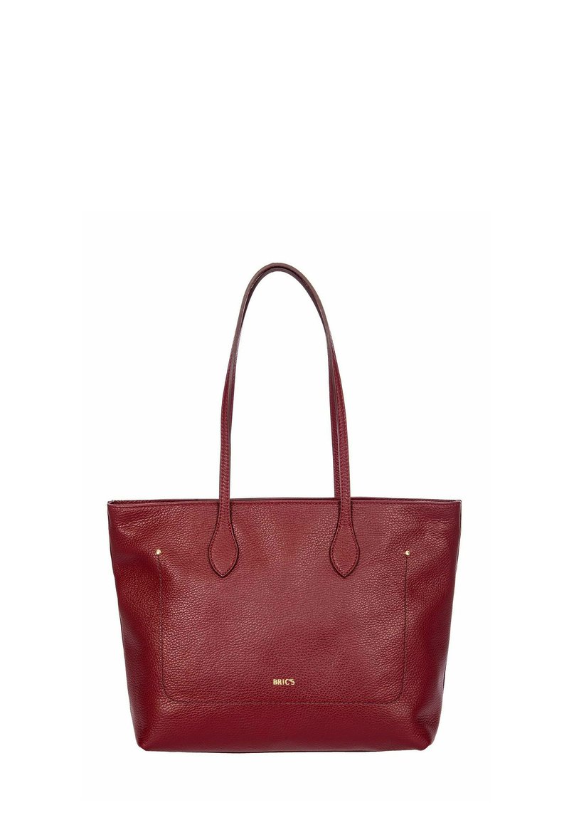 Un sac fourre-tout en cuir rouge avec de longues poignées, une surface texturée et un design plat. Il comporte une poche avant et une subtile marque dorée.