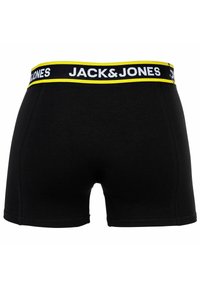 Svarta boxershorts med en bred elastisk midjeresår med en gul kant och vit text "JACK & JONES." Släta tyger, midjehöjd.