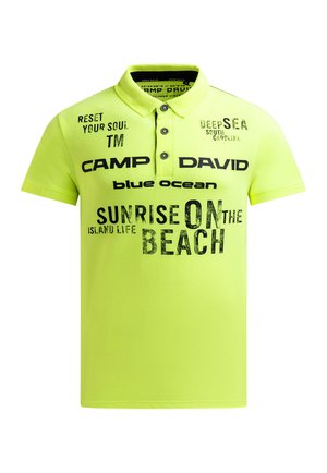 Bright yellow-green polo shirt with black text: "CAMP DAVID," "SUNRISE ON THE BEACH," "blue ocean," and other beach-themed phrases.