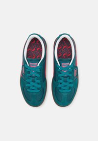 Baskets bleu sarcelle avec des accents roses, en suède et mesh, bout rond, lacets plats, logo sur la languette et semelle intérieure rouge à motifs.