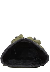 Sac à dos vert olive vide avec doublure intérieure noire, ouvert pour révéler un compartiment principal spacieux et des poches arrière rembourrées.