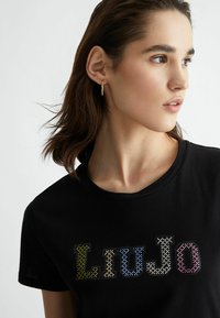 T-shirt nera a maniche corte con logo "LIU JO" decorato con strass colorati in diverse tonalità di verde, blu e rosa.