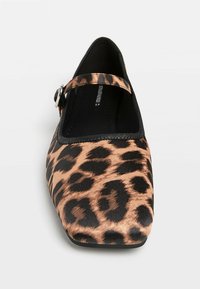 Ballerines à imprimé léopard avec une bordure noire, dotées d'un bout arrondi et d'une bride ajustable avec une finition en argent pour un maintien sécurisé.