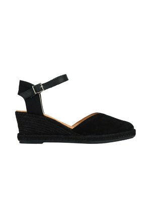 Sandalia de cuña de ante negro con tira en el tobillo, tacón envuelto en yute y diseño de punta redondeada. Parte superior texturizada y suela sólida.
