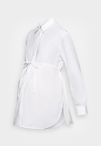 Vit skjorta med långa ärmar, krage, knappfront och ett bälte i midjan. Tillverkad av lättviktsmaterial med en slät textur.