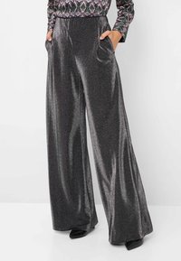 Wijduitlopende broek in een glanzende zwarte stof, met een hoge taille en zijzakken. Zachte textuur met een subtiele metallic glans.