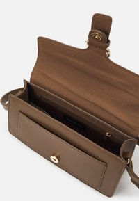 Brown synthetic leather crossbody bag with gold hardware, a spacious interior, zippered pocket, and a front flap with a snap closure.