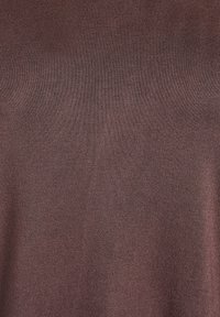 Pruun, soonikkoesise mustriga ülasosa pehme tekstuuriga. Omab lihtsat, keha järgivat disaini ning sileda viimistlusega ilma nähtavate mustrite või aksentideta.