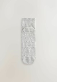 Világosszürke zokni bordázott mandzsettával, tapadást és stabilitást növelő texturált tapadópöttyökkel a talpon.