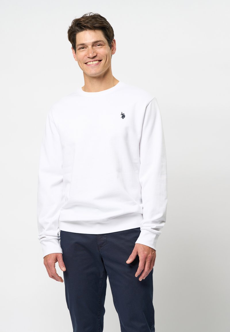 Witte sweatshirt met een ronde halslijn en lange mouwen, voorzien van een klein zwart logo op de linkerborst. Zacht katoen, losse pasvorm.