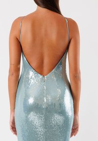 Vista posteriore di un vestito di sequin blu chiaro con una scollatura a V profonda e spalline sottili, che mette in evidenza una texture liscia e lucida e una silhouette aderente.