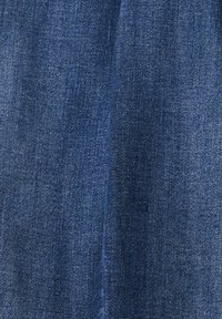 Tela de mezclilla en un tono azul oscuro, con una textura suave y un patrón de tejido diagonal. Zonas ligeramente desteñidas visibles.
