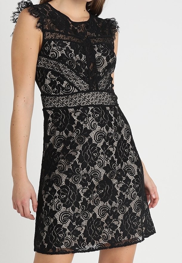 Robe noire en dentelle avec motifs floraux, design sans manches, épaules à volants et taille cintrée. Présente une texture semi-transparente subtile.