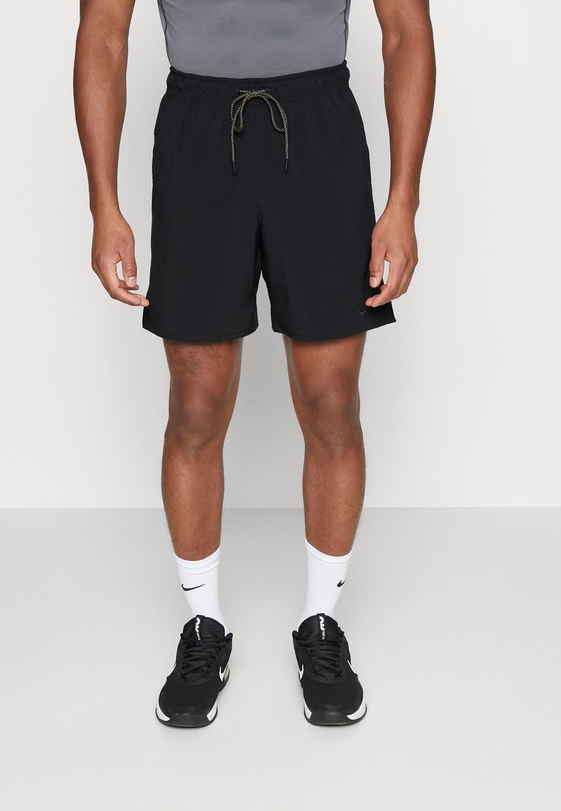 Shorts de sport noirs avec une ceinture élastique et un cordon de serrage. Confectionnés en tissu léger, ils offrent une coupe décontractée et des poches latérales.